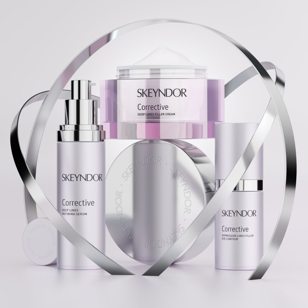 Die Skeyndor Corrective-Hautpflegeprodukte - einschließlich Serum, Creme und Filler - sind mit silbernen Zierringen vor einem hellen Hintergrund angeordnet.