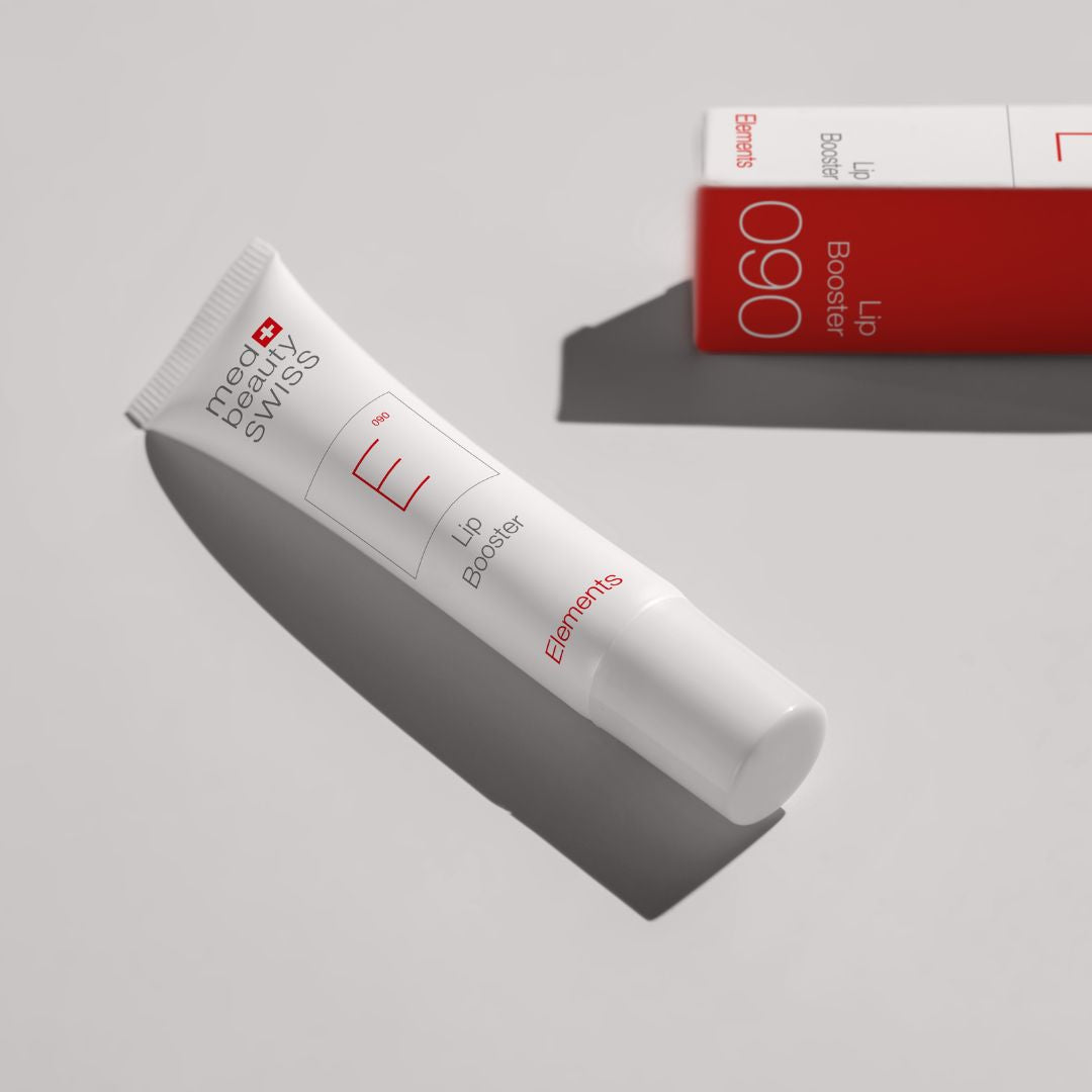 Zwei Tuben der Lippenprodukte von Med Beauty Swiss mit den Bezeichnungen Lip Peel und Lip Booster befinden sich auf durchsichtigen Gelpflastern mit weißem Hintergrund. Die Verpackung ist weiß mit roter und grauer Schrift.