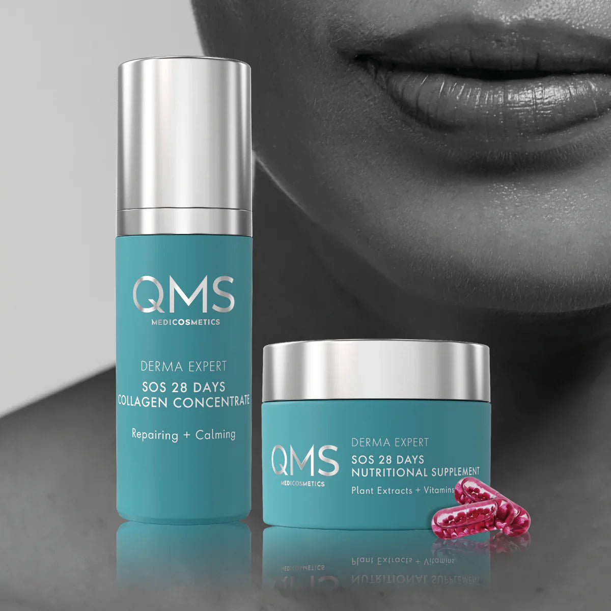 Zwei blaue Hautpflegeprodukte von QMS Medicosmetics, eine hohe Flasche und ein Tiegel, werden mit rosa Kapseln präsentiert. Als Hintergrund dient eine Nahaufnahme des unteren Gesichts einer Frau in Graustufen.