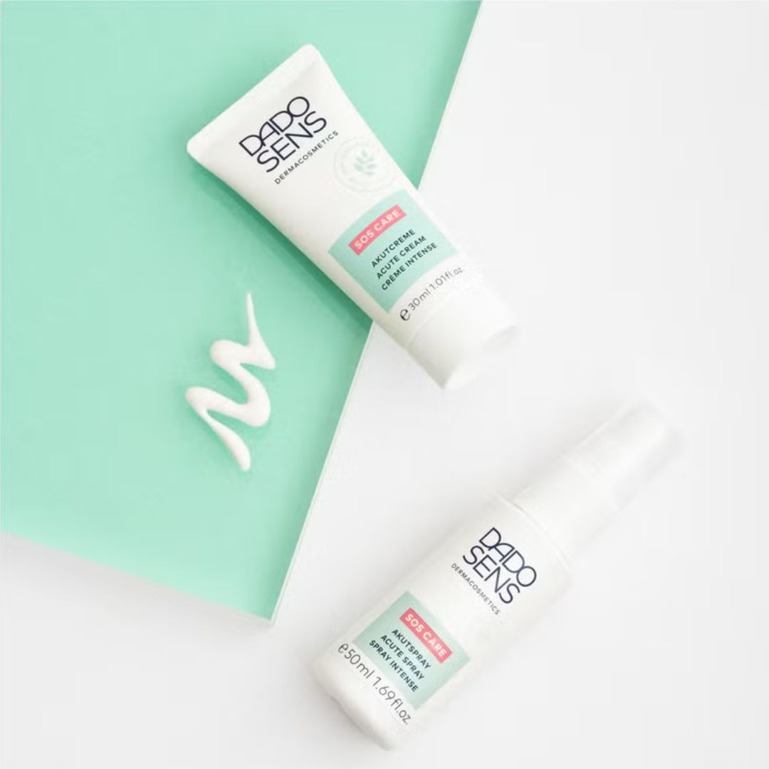 Zwei DADO SENS-Hautpflegeprodukte stehen auf einer mintgrünen Fläche, daneben ein verwirbelter Cremeschnipsel. Die Produkte sind mit der Aufschrift Pro Balance versehen, darunter eine Tube und eine Sprühflasche.
