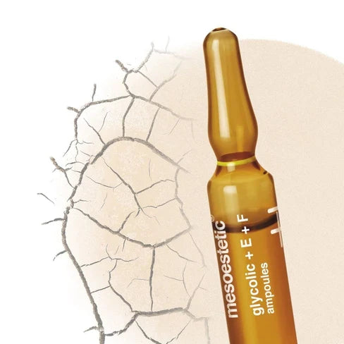 Eine braune Ampulle mit der Aufschrift mesoestetic glycolic + E + F Ampullen ist neben rissiger, trockener Haut auf hellem Hintergrund abgebildet.