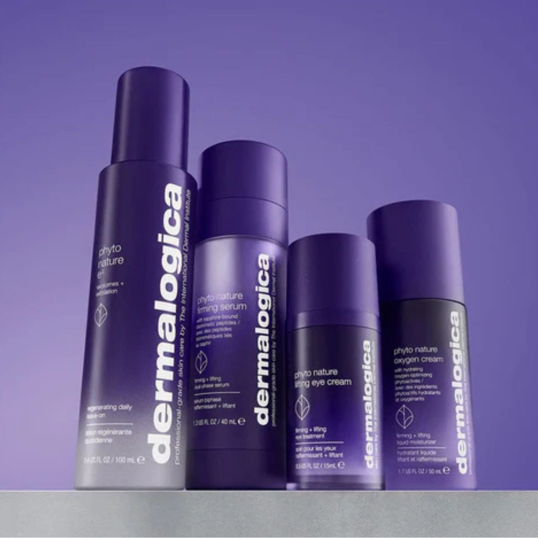 Vier lilafarbene Dermalogica-Hautpflegeprodukte aus der Phyto Nature-Linie sind aufrecht auf einer grauen Fläche angeordnet, wobei ein lilafarbener Hintergrund ein zusammenhängendes, stilvolles Display bildet.