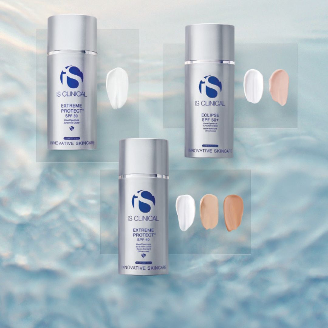 Drei Fläschchen mit Sonnenschutzmitteln von iS Clinical mit Farbmustern in den Farben Weiß, Hellbeige und Mittelbeige auf einem blauen, wässrigen Hintergrund.