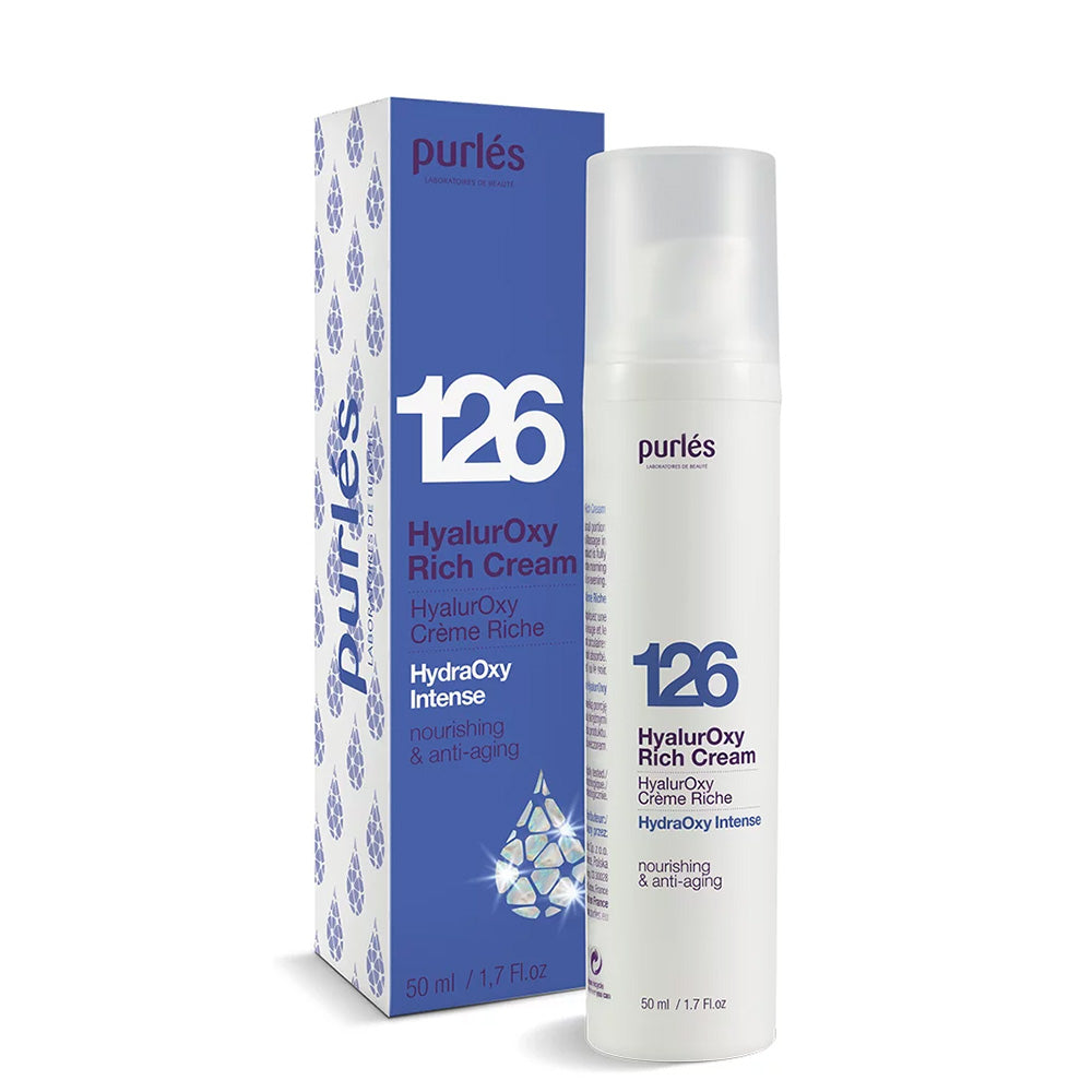 Eine 50-ml-Flasche Purlés HydraOxy Intense 126 HyalurOxy Rich Cream mit Schachtel. Die Verpackung ist weiß mit blauen und violetten Akzenten und enthält einen Text über die nährenden und Anti-Aging-Vorteile.