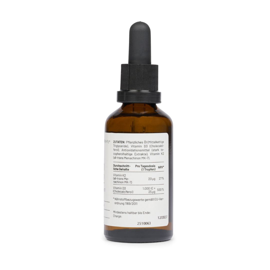 Eine Tropfflasche aus braunem Glas mit schwarzer Kappe und weißem Etikett zeigt "medigevity - medi Vitamin D3 & K2 Tropfen" in deutscher Sprache, zusammen mit Nährwertangaben. Die medigevity Flasche ist vor einem schlichten weißen Hintergrund abgebildet.