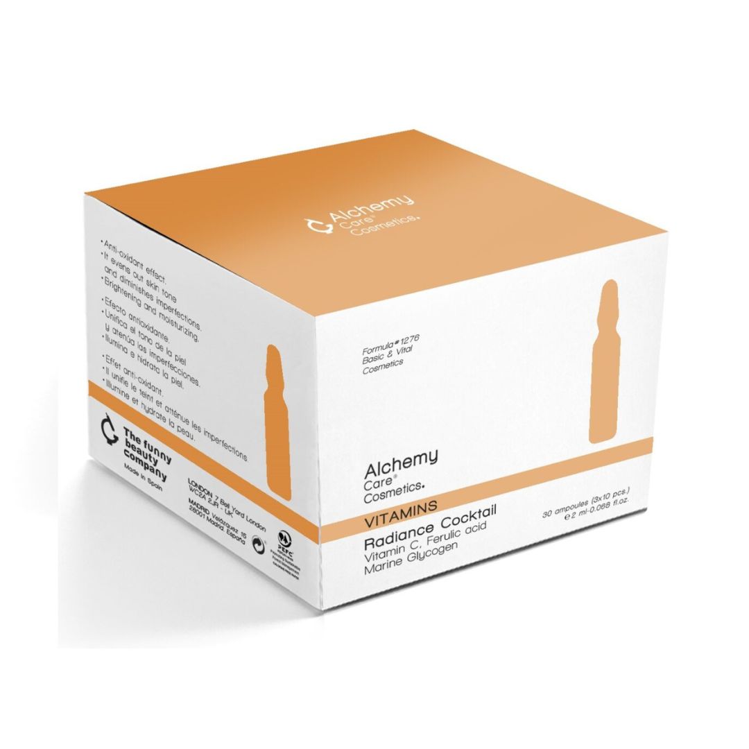 Eine weiß-orangefarbene Schachtel mit der Aufschrift Alchemy Care Cosmetics Radiance Cocktail, mit einem Text, der die Inhaltsstoffe Vitamin C, Ferulasäure und marines Glucan hervorhebt, und einer Ampullenabbildung auf der Verpackung.