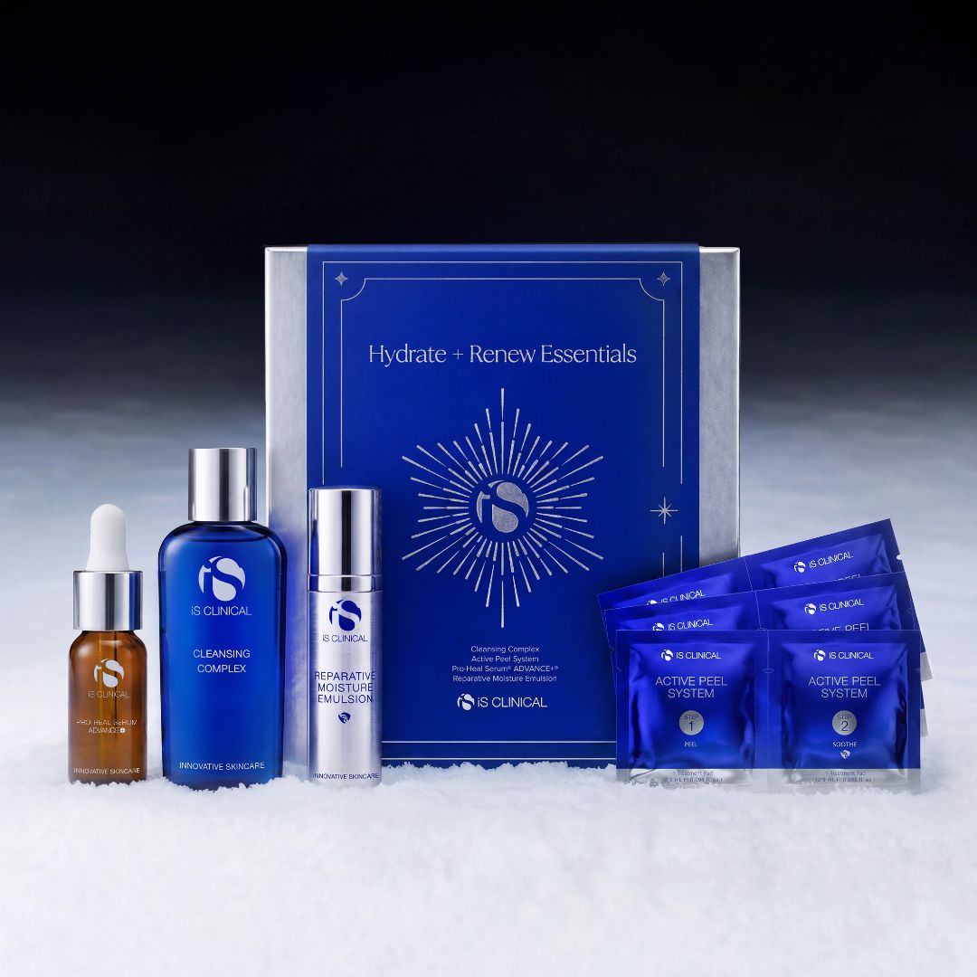 Das iS CLINICAL Hydrate+ Renew Essentials-Set, bestehend aus einer Pro-Heal-Serum-Tropfflasche, zwei Pumpflaschen, einer blauen Geschenkbox und vier Folienpäckchen mit Cleansing Complex, auf einer weißen Unterlage.