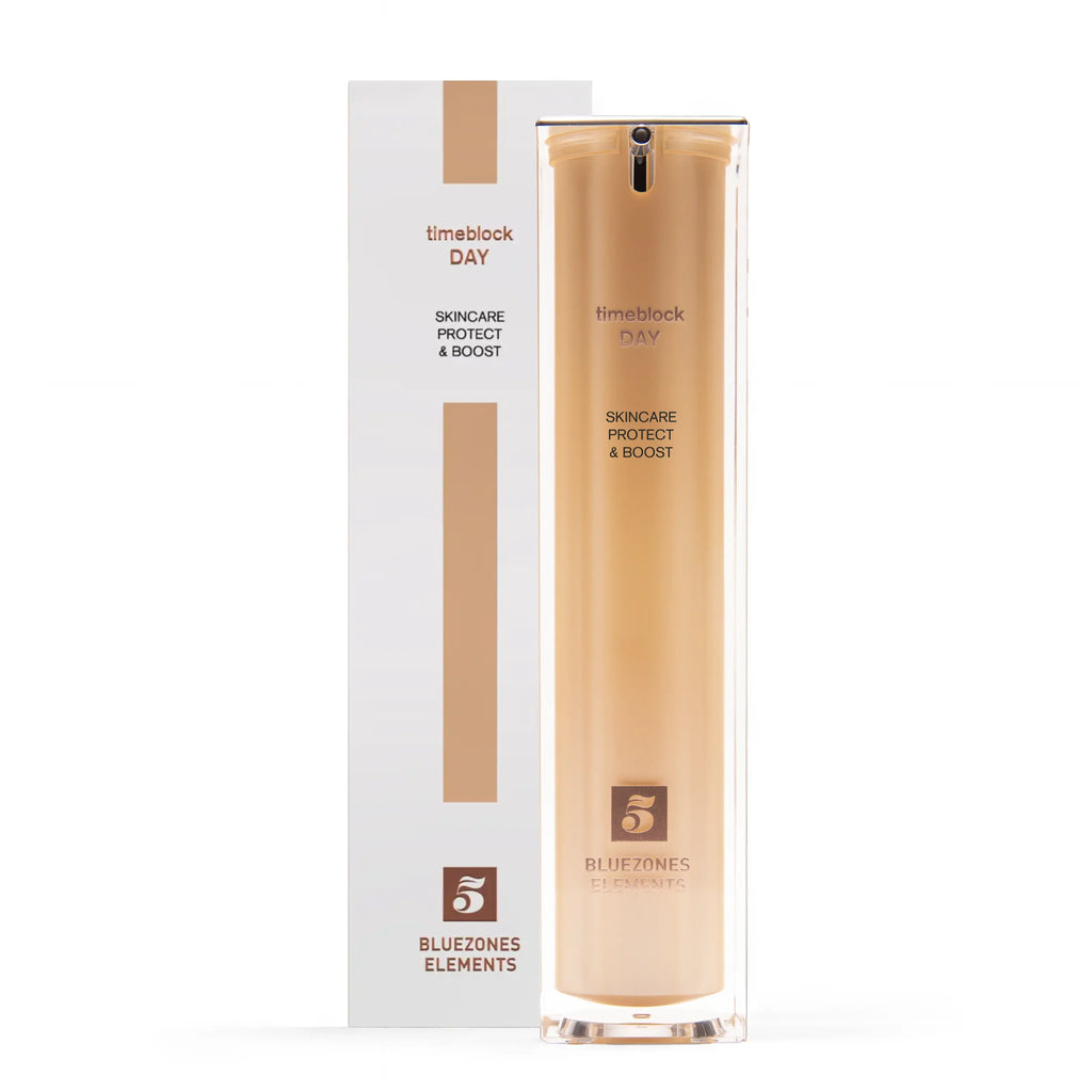 Ein hoher, goldener Flakon von timeblock® DAY by timeblock® steht vor seiner weißen Schachtel, die das Bluezones Elements-Logo und einen minimalistischen Look aufweist.