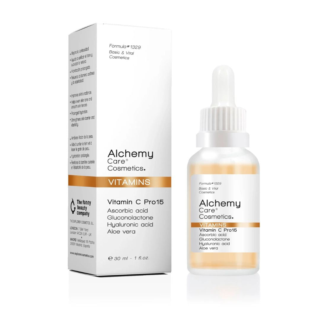 Eine Flasche und eine Schachtel von Alchemy Care Cosmetics Alchemy - Serum Vitamins Vitamin C Pro15, mit Ascorbinsäure, Gluconolacton, Hyaluronsäure und Aloe Vera. Die Verpackung ist weiß mit goldenen und orangefarbenen Akzenten.